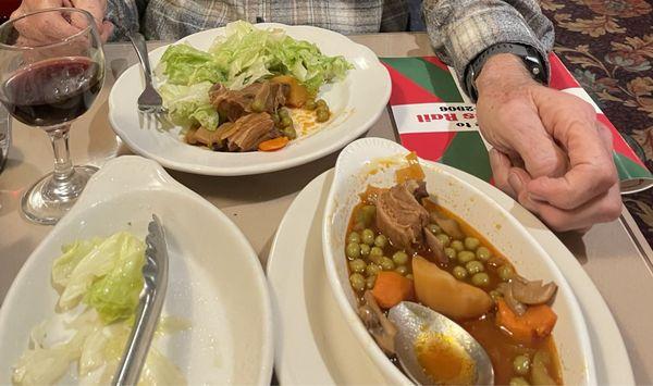 Plain lettuce salad, lamb soup with canned peas and carrots. Included little glass of wine.