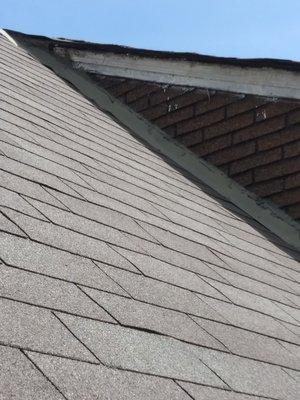 Roof flashing installed above shingles and lifting up.