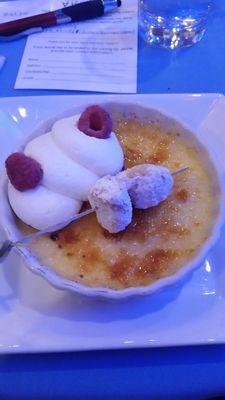 Creme brulee with mini beignets, whipped cream, and raspberries.