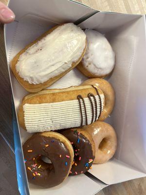 Maple donut, lemon donut, almond vanilla butter cream, chocolate frosted raised donut, chocolate frosted cake donut, and raised donut.