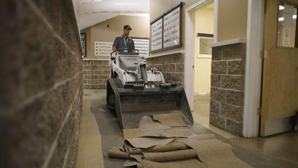 SERVPRO team member takes up flooring after a flood in a commercial building.