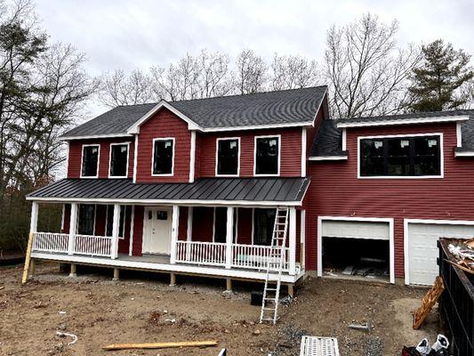 New siding installation, metal roof above 1st story and asphalt shingles roof.