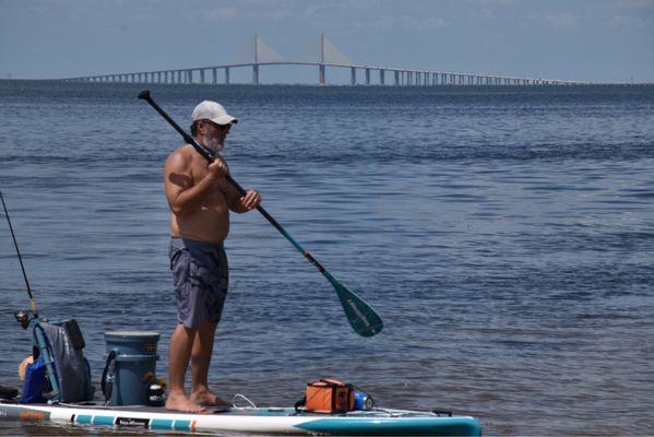 A paddle boarding fisherman