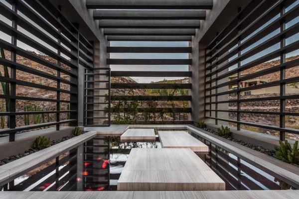 Stunning styled koi pond with a modern looking backyard walkway.