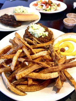 1/3 lb. Carolina Burger With home cut fries sitting in front of a hamburger steak and salad.