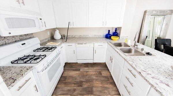 Full-equipped kitchen with granite countertops and white appliances