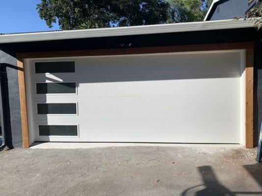 Another beautiful contemporary garage door with glass on the left-hand side, going all the way down each section