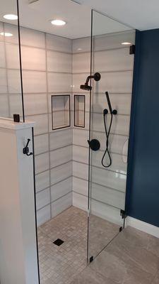 Bathroom remodel featuring a modernized shower cabin with updated fixtures and clean, sleek tile work.