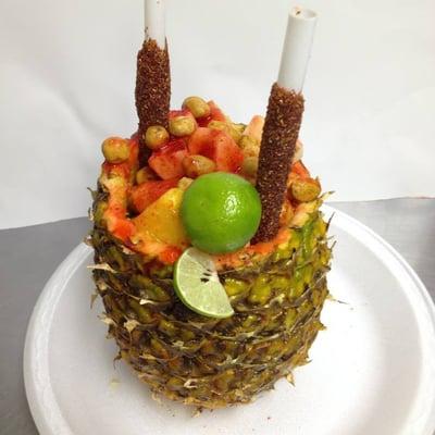 Our infamous "Pina-Loka", it is a hollowed out pineapple filled with pineapple, apple, japanese peanuts, chamoy, lime and Tajin chile powder