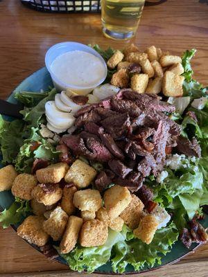 Flat Iron Steak Salad with Blue Cheese dressing. Ask for purple onions and bacon for a better taste