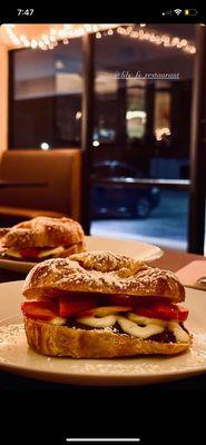 Flaky croissant filled with chocolate, banana, and strawberries, topped with powdered sugar--the perfect mix of sweet and fresh!