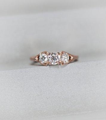 A modern twist on a classic three stone ring.