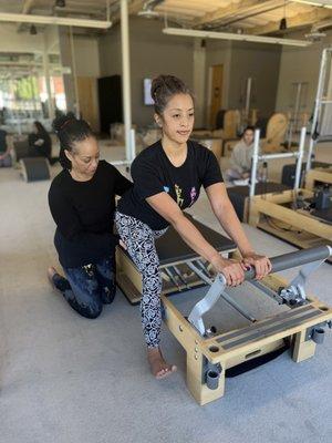 Stella positions Josie on the Reformer.