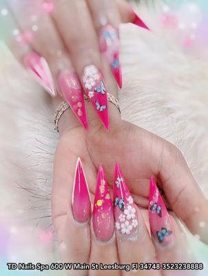 Empower Your Style: Stiletto Nails in Pink with Floral Elegance and Butterfly Grace.