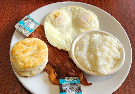 The Mama Mary breakfast with grits, biscuit  and bacon with over easy eggs