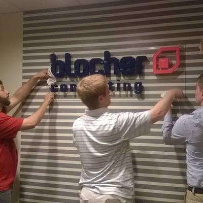 Some of the team putting up the new sign in our new office space.