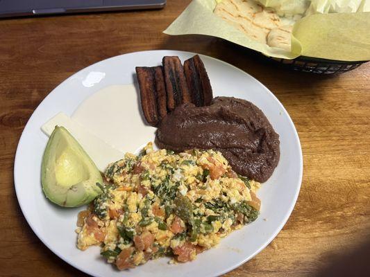 Desayuno tipico con huevos picados con vegetales.