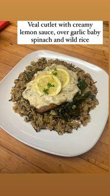 Chicken cutlet with creamy lemon sauce over garlic, baby, spinach, and wild rice