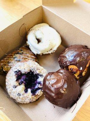 Top clockwise: cinnamon roll with cream cheese frosting; chocolate ganache cruffins x2; blueberry danish and blueberry scone