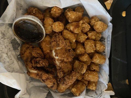 Chicken strips and greasy tater tots with teriyaki sauce