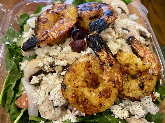 Large salad with grilled shrimp.