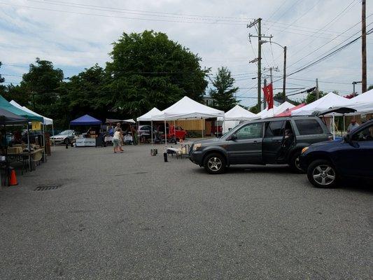 After 11am, empty tents and vehicles in the lot.