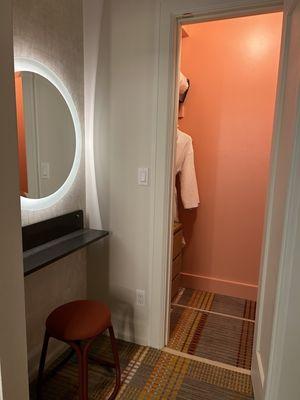 A little nook of a vanity and a very smart presentation of a small closet that feels bougie