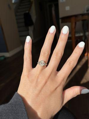 Oval diamond engagement ring set in a gold bezel band with sapphire and peridot side stones