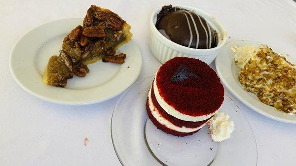 Assorted thanksgiving desserts (pecan pie, res velvet cake, chocolate bomb, carrot cake)