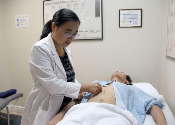 Dr. Li is performing acupuncture treatment.