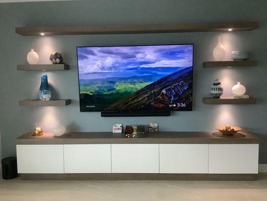 Living room built-in with puck lighting and floating shelves