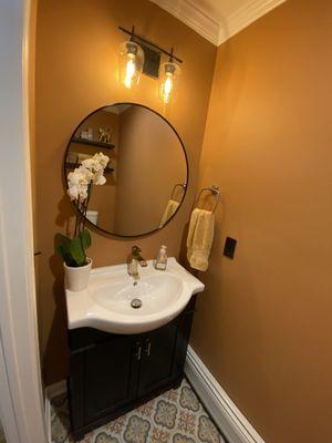 Tuscan inspired powder room with shallow depth vanity, polished nickel fixtures and patterned porcelain tile floor.