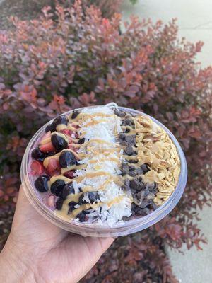 Peanut Butter Acai Bowl with granola, coconut, blueberries, strawberries, chocolate chips, peanut butter drizzle, and honey drizzle! YUMMM