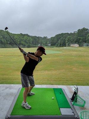 Inside the covered range with mats equipped with Power Tee (automatic teeing system).