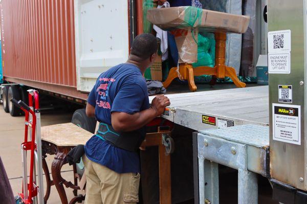 Onsite at storage. The muscle handing items up into container.