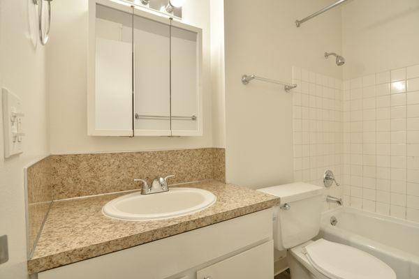 Bathroom has large linen closet with shelves and drawers behind the door