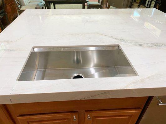 New stainless steel sink install under quartzite countertop.