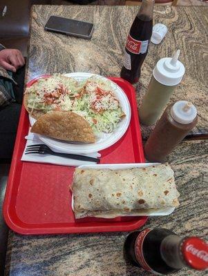 Burrito rolled tacos coke, hot sauce in squeeze bottles.