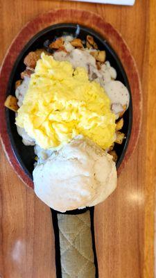 Country skillet with scrambled eggs, potatoes, gravy and a huge delicious biscuit