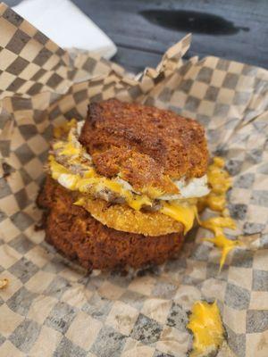 Biscuit buns with an egg, two smash patties, cheese and hashbrown patty in the middle.