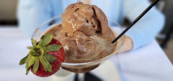 Chocolate desert with some sort of alcohol served with a spoon and straw