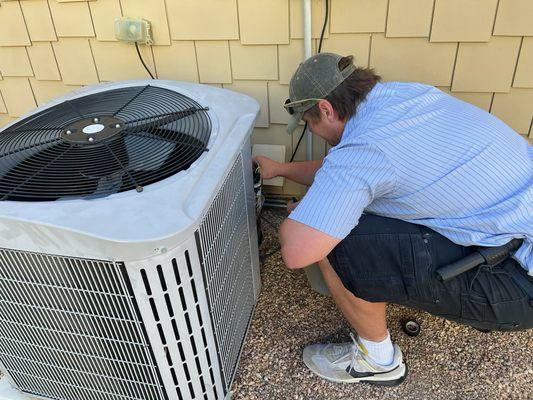 Technician Sam Nevin checking the connection on the condenser