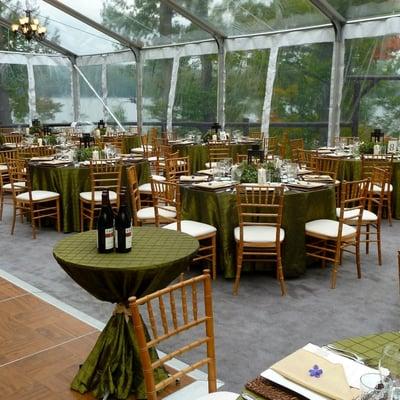 Structure Clear Top Tent with Natural Chiavari Chairs, Moss Linen, Wrought Iron Lanterns & Chandeliers, and Rattan Chargers