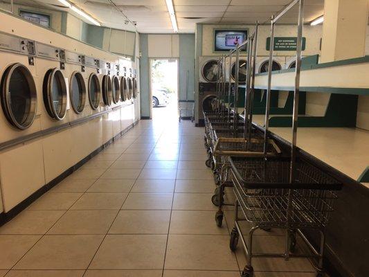 Long line of folding tables and neat row of laundry carts.