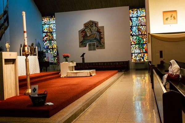 Woman praying in front of the blessed sacrament.