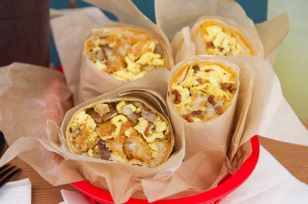 Breakfast burritos!!  Large flour tortilla stuffed with 3 scrambled eggs, cheddar cheese, & potato.  Add bacon, sausage, or chorizo