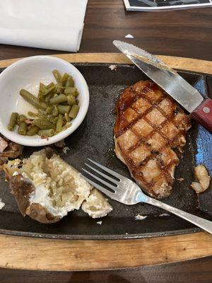 Pork chop dinner with green beans and baked potatoe.