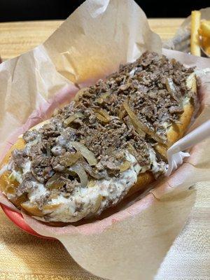 Cheesesteak hoagie with xtra cheese and fried onions .