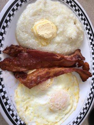 Eggs over medium, crispy bacon and grits.