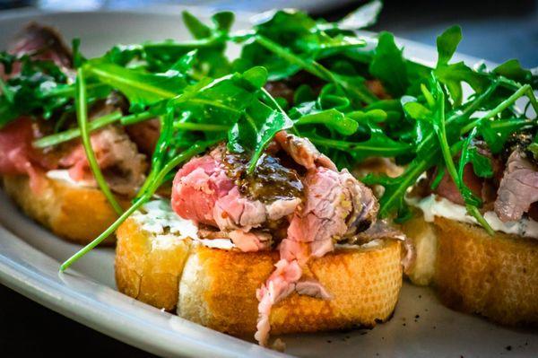 London Broil Bruschetta-mustard & spice medium rare beef, herbed cream cheese, grilled baguette chili oil, arugula